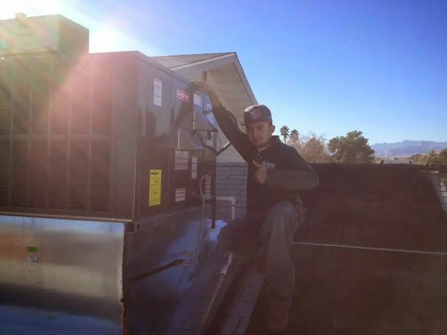 HVAC technician performing Air Duct Repair on a rooftop unit in Lake of the Pines